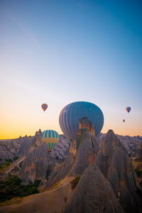 Hot air balloons flying against sky during sunset