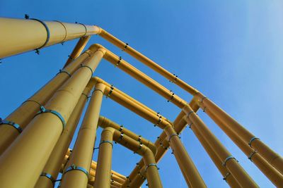 Low angle view of pipeline against clear blue sky