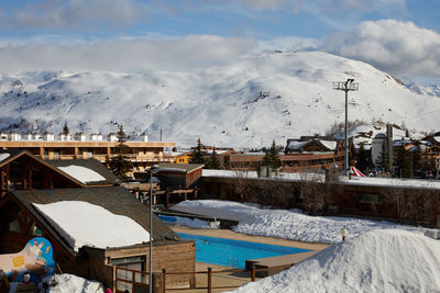 Snow covered buildings against sky