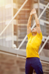 Midsection of man with yellow umbrella against blurred background