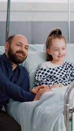 Portrait of happy family sitting on sofa at home