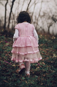 Rear view of girl walking on tree