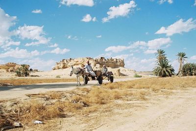 Panoramic view of people on landscape against sky