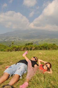 High angle view of woman relaxing on field against sky