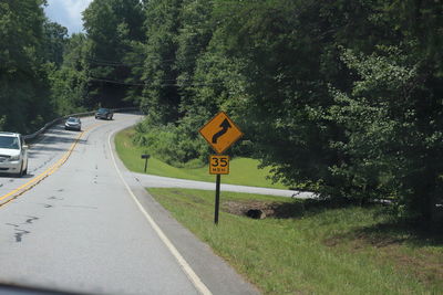 Road sign by trees