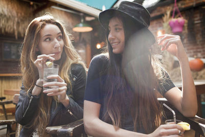 Portrait of happy young woman drinking glass