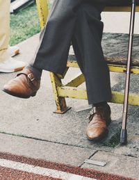 Low section of man sitting on sidewalk