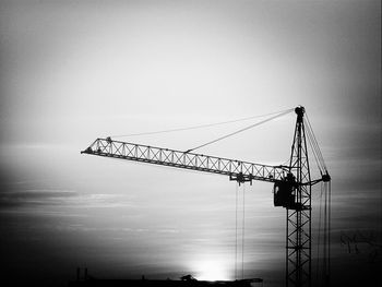 Low angle view of crane against sky during sunset