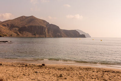 Scenic view of sea and mountains against sky