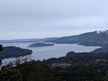 Scenic view of sea and mountains against sky