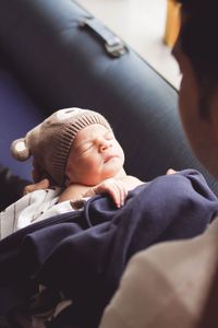 High angle view of father with sleeping baby boy at home