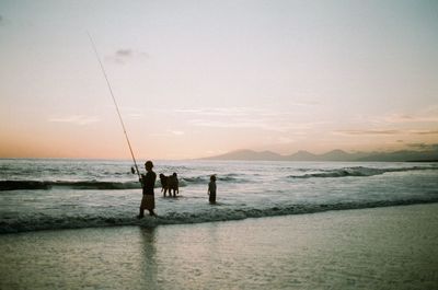 Rear view of man standing at beach