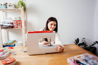 Portrait of woman sitting on table at home