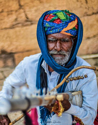 Portrait of senior man holding musical instrument outdoors