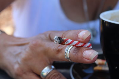 Cropped image of woman smoking joint outdoors