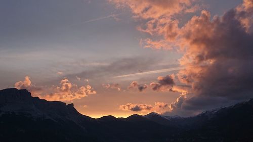 Low angle view of silhouette mountains against dramatic sky