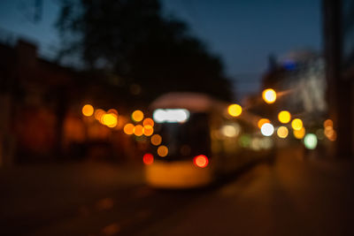 Defocused image of illuminated city street at night