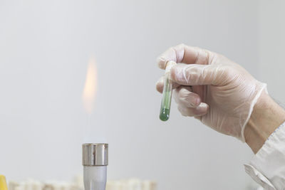 Close-up of hand holding lit candle