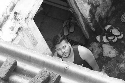 High angle portrait of young man standing outside house