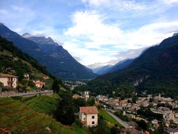 Scenic view of townscape by mountains against sky