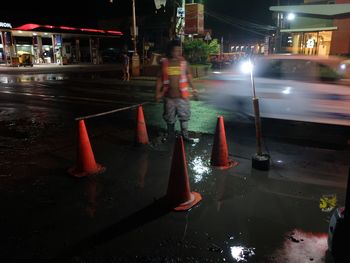 Man with umbrella on street at night