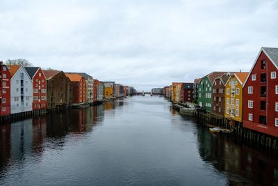 Canal amidst houses and buildings against sky
