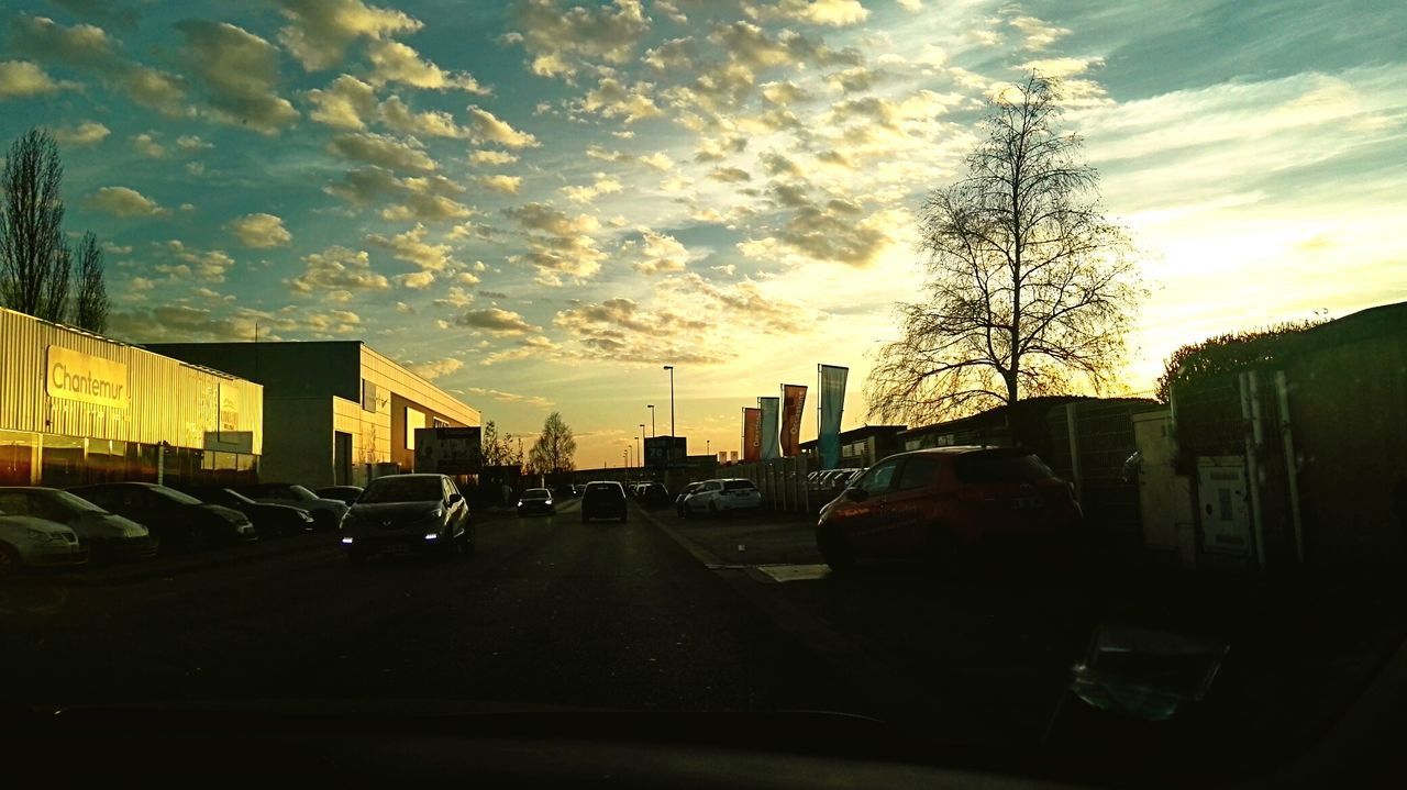 building exterior, car, transportation, architecture, sunset, built structure, sky, land vehicle, mode of transport, street, city, silhouette, road, cloud - sky, cloud, residential structure, residential building, building, tree, dusk