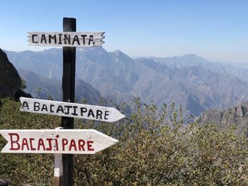 Information sign on mountain against sky