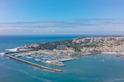 High angle view of city by sea against sky