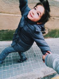 Cropped image of mother with cute son walking on sidewalk