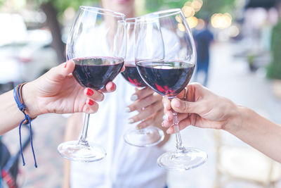 Midsection of woman holding wine glass