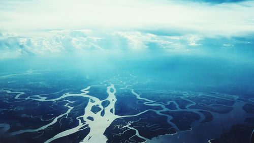 Aerial view of delta against cloudy sky