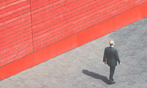 Full length of woman standing against wall