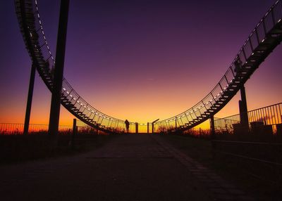 Low angle view of bridge against sky at sunset