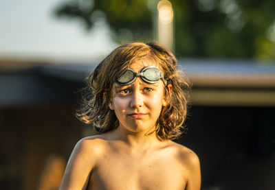 Portrait of a shirtless boy wearing swimming glassed on his head