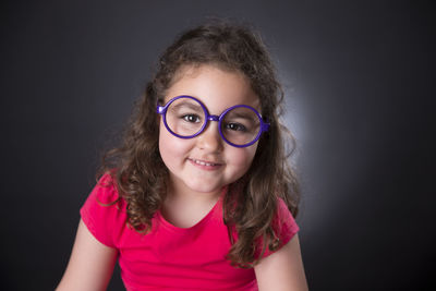 Portrait of smiling girl against black background