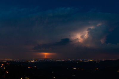 Illuminated city against sky at night