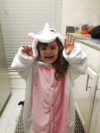 Happy girl wearing hat standing against wall