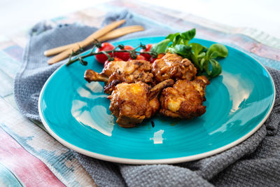 High angle view of chicken meat in plate on wooden table