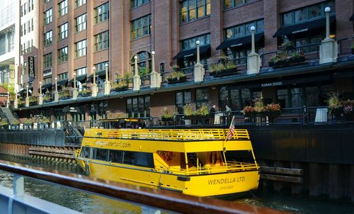 Yellow boats moored by buildings in city
