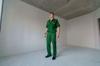 Full length of soldier standing against wall