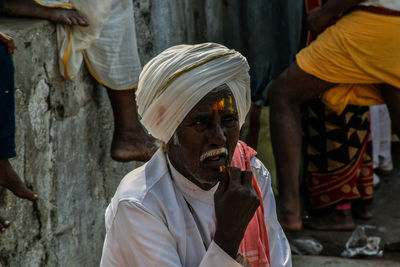 Senior man in turban sitting outdoors at market