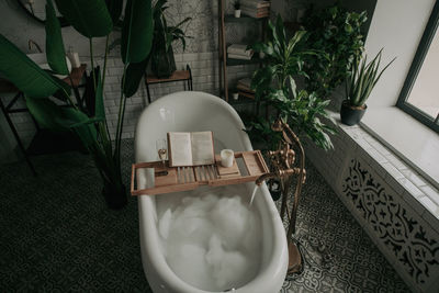 Luxury interior of big bathroom at modern african style with oval bathtub in natural lighting