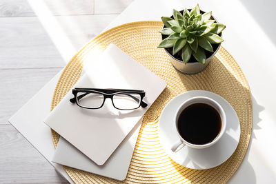 Office desk with coffee cup, succulent plant, eyeglasses and notepad. business table.