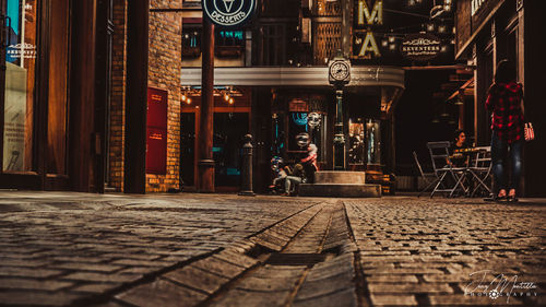 Man and woman on street amidst buildings in city