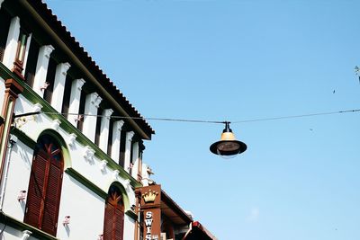 Low angle view of street lamp hanging against clear sky