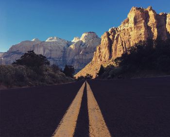 Road by mountain against sky