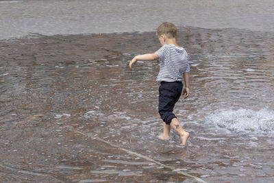 Rear view of boy on water