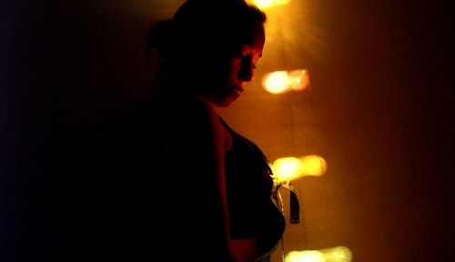 Side view of man smoking against sky at night