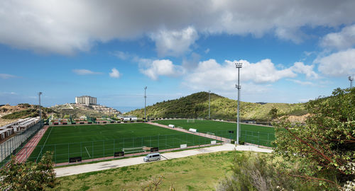 Scenic view of grassy soccer field against cloudy sky